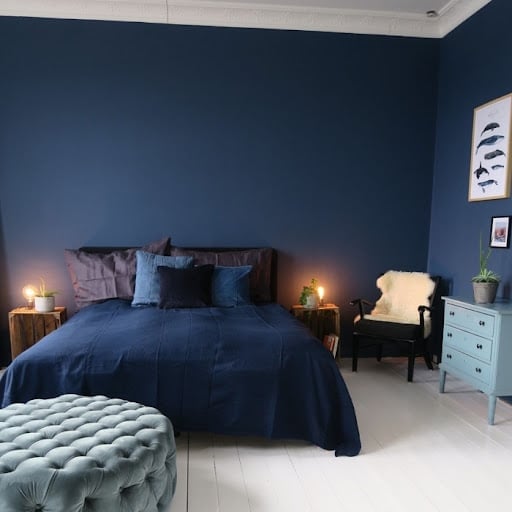 Chambre d'ado, à la peinture murale bleu nuit. Le ton de la décoration est adapté aux murs.