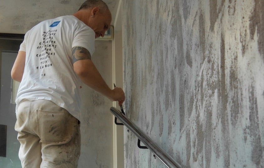 Un de nos peintre décorateur travaille sur une patine béton ciré dans un hôtel qui se veut industriel